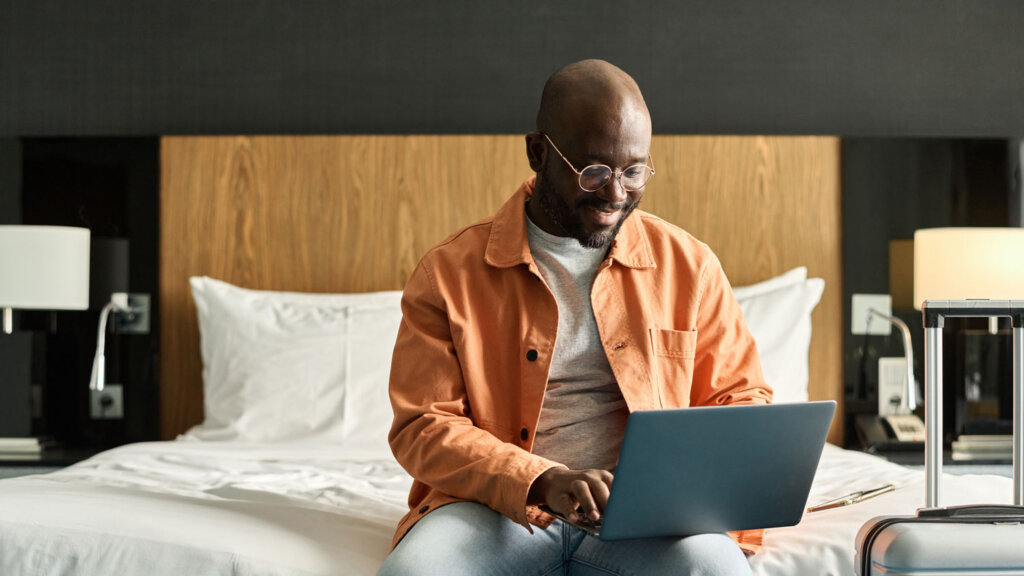 Travel advisor using a laptop in a hotel room to manage personalized client communication